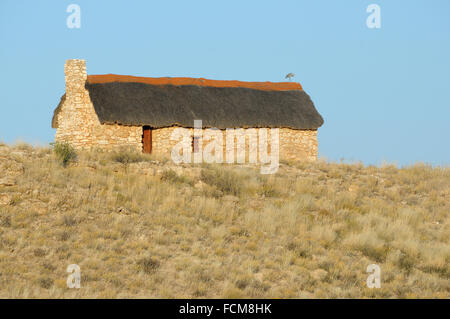 Colon historique home à Auchterlonie dans le parc transfrontalier de Kgalagadi avec héron à tête noire sur le toit. Banque D'Images