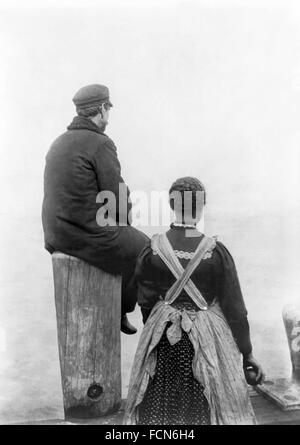 Ellis Island. Immigrantst Deux immigrants ( ?) sur le dock à Ellis Island, New York, NY, c.1912. La photographie originale est intitulée "Deux émigrants sur le bord de la mer" (Bibliothèque du Congrès). Banque D'Images