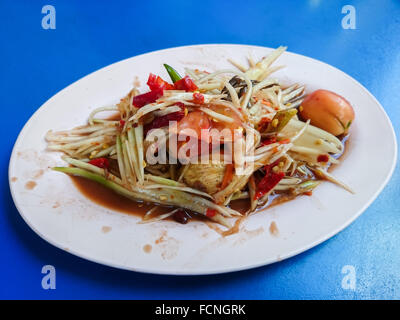 Somtum, salade de papaye au crabe épicé, nourriture locale thaïlandaise plat sur table bleue Banque D'Images