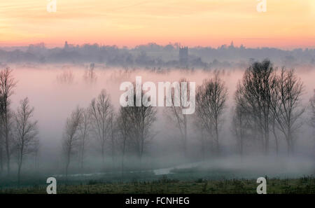 Brume sur le Dedham Vale, avec rivière Stour et Église Dedham, Suffolk, pays de Constable, au coucher du soleil, l'hiver. Banque D'Images