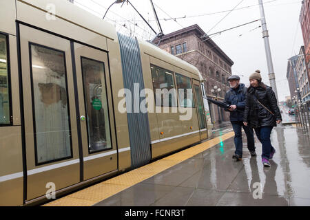 Seattle, USA. 23 Jan, 2016. Couple à l'Occidental Mall Station au cours de la première ligne de tramway s'Hill course inaugurale - le 23 janvier 2016. La première colline est un tramway 4 kilomètres de long qui relie Pioneer Square et la colline du Capitole par le Quartier International, Yesler Terrace, et première colline. C'est la deuxième ligne mis en œuvre après le Sud Lake Union Streetcar a ouvert ses portes en 2007. Crédit : Paul Gordon/Alamy Live News Banque D'Images