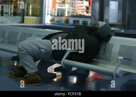 New York, New York, USA. 23 Jan, 2016. Un homme dort dans le Staten Island Ferry terminal St George pendant la tempête Jonas. Une interdiction de voyager a été en place pendant des heures, mais le traversier exploité encore. Les projections de neige pour Staten Island avait environ 12-18dans, avec des rafales jusqu'à 50 milles à l'heure. La fin de l'après-midi, les bus ont cessé de fonctionner et une interdiction de voyager a été appliquée par le NYPD. Ce manque de transport brin de nombreux habitants de Staten Island qui avait pris le ferry à la maison. Les gens ont été forcés d'essayer de marcher jusqu'à leur destination dans le blizzard. Gouverneur de New York Eliot Spitzer a déclaré un STA Banque D'Images