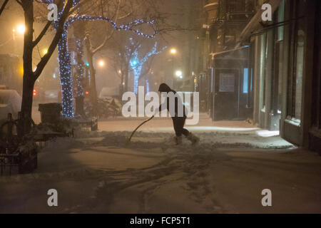 New York, États-Unis. 23 Jan, 2016. Une femme pelleter la neige sur Montague Street, Brooklyn. Les premières chutes de neige tout au long de la matinée que New York se prépare pour la côte Est de l'historique de Blizzard. Crédit : Louise Wateridge/Pacific Press/Alamy Live News Banque D'Images