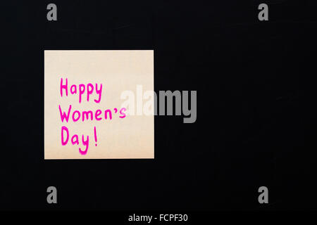 Bonne Journée de la femme. Autocollant rose sur noir tableau, 8 mars. Selective focus Banque D'Images