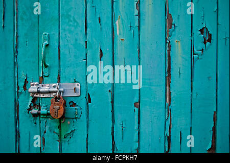 Peinture écaillée bleue sur la porte en bois avec serrure rouillée Banque D'Images