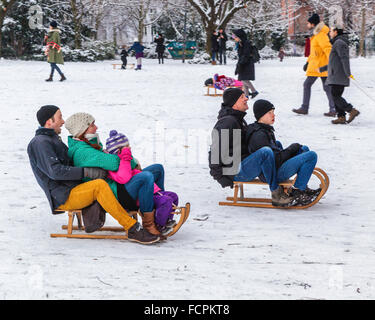 Familles et enfants avec des traîneaux sur une pente enneigée dans un parc public en hiver, Berlin, Mitte, Volkspark suis Weinbergsweg, Banque D'Images