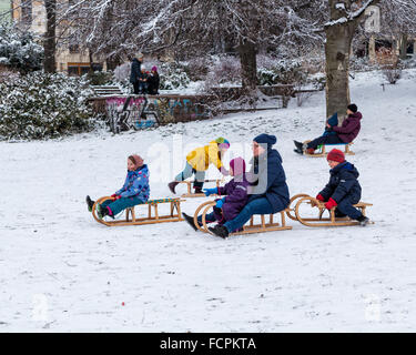 Familles et enfants avec des traîneaux sur une pente enneigée dans un parc public en hiver, Berlin, Mitte, Volkspark suis Weinbergsweg, Banque D'Images