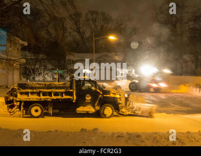 Merrick, New York, USA. 24e Janvier 2016. Ville de Hampstead deux chasse-neige, un petit un labourant un cul de sac, dead end side street, et une grande charrue sur la grande route qui mène à elle, nettoyer les routes sont alors que Jonas Blizzard continue à rassembler de la neige et des bourrasques de vent dangereuses à Long Island. Gov. Cuomo a interdit les voyages, l'arrêt L.I.'s routes et chemins de fer, en raison de conditions dangereuses, et la tempête de 2016 a déjà baissé d'environ deux pieds de neige sur la rive sud de la ville. Credit : Ann E Parry/Alamy Live News Banque D'Images