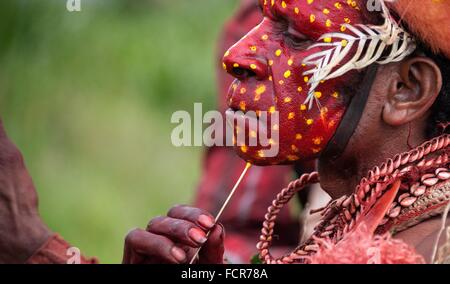 Une tribu s'applique la peinture pour le visage pendant la célébration des tribus des hauts plateaux au Mount Hagen Culture Voir le 8 août 2013 à Mount Hagen, la Papouasie-Nouvelle-Guinée. Banque D'Images