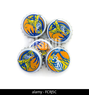 Pile de Tiger Beer Bottle Tops sur fond blanc Banque D'Images