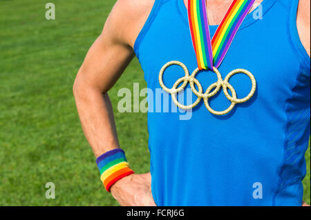 RIO DE JANEIRO - le 4 février 2015 : médaille d'anneaux olympiques se bloque à partir de la gay pride ruban arc-en-ciel sur la poitrine d'un athlète. Banque D'Images