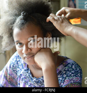 Pearl Lagoon, le Nicaragua - Juillet 16, 2015 : belle fille créole avec funky cheveux coiffure un par sa mère. Banque D'Images