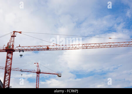 Site avec deux grues rouge contre le ciel bleu Banque D'Images