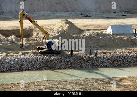 Egyptiens regarder sur le rivage au début d'une construction sur les rives du nouveau canal de Suez. Banque D'Images