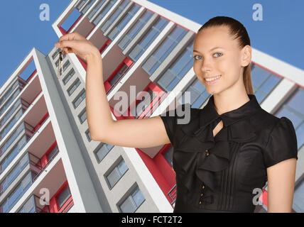 Jeune fille debout sur fond d'immeuble et est holding keys Banque D'Images