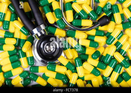 Châssis rempli de médecine de capsules, en vert et jaune, et stéthoscope. Banque D'Images