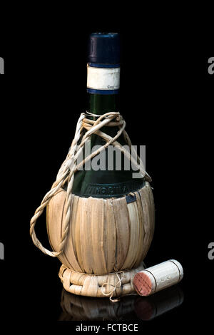Vieille bouteille de vin italien sur fond noir Banque D'Images