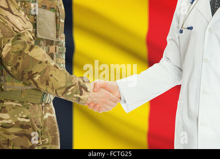 Soldat en uniforme et doctor shaking hands avec drapeau national sur l'arrière-plan - Belgique Banque D'Images