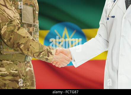 Soldat en uniforme et doctor shaking hands avec drapeau national sur l'arrière-plan - Ethiopie Banque D'Images