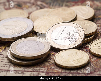 Pièces en euro sur la vieille carte du monde. Photo Macro. Banque D'Images