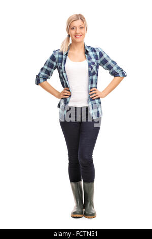 Portrait d'une jeune femme en chemise à carreaux bleu et vert des bottes en caoutchouc isolé sur fond blanc Banque D'Images