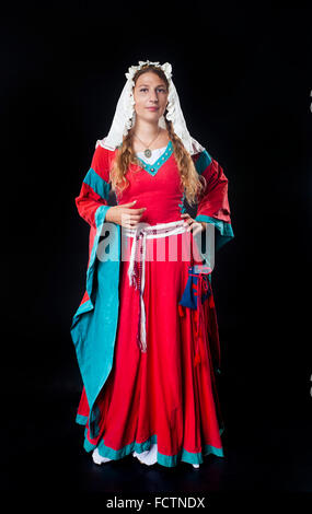 Studio/portrait d'une fille à l'époque médiévale robe rouge et foulard sur fond noir Banque D'Images