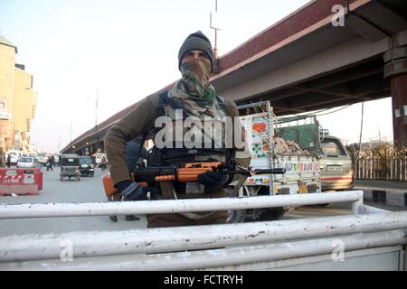 Un homme de la police monte la garde près d'une barricade temporaire en place pour l'opération de recherche de surprise à Srinagar, la capitale d'été du Cachemire indien, 25 janvier 2016. La sécurité a été renforcé dans le Cachemire indien avant les célébrations de la fête de la République indienne prévue le 26 janvier.(Basit Zargar/ Alamy Live News) Banque D'Images