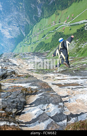 Cette base wingsuit juste cavalier est sortie de la falaise vers le bas. Il va voler le long de la paroi de la falaise et d'obtenir une montée d'adrénaline de ce fait. Banque D'Images