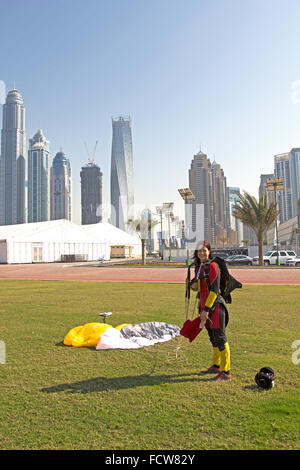 Cette fille parachutiste est très heureuse qu'elle a atterri sur le bouton Enregistrer de la zone d'herbe dédié sur l'aérodrome, après un saut sur Dubaï Palm. Banque D'Images