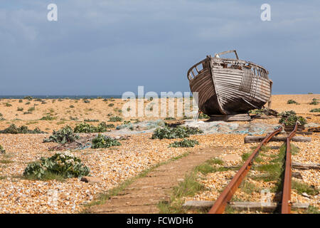 Vieux bateau de pêche abandonnés et transports voies sur la plage de galets à Dungeness, dans le Kent, Angleterre Banque D'Images