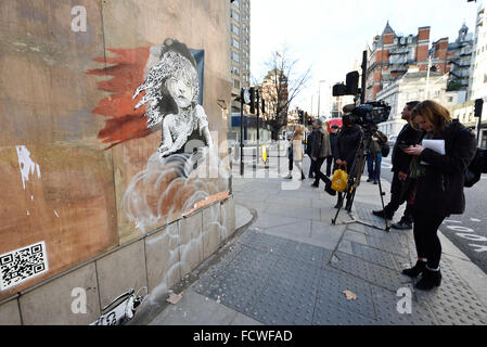 Londres, Royaume-Uni. 25 Jan, 2016. Ouvriers agissant à l'ordre du propriétaire du bien essayer d'enlever la nouvelle Art Banksy en face de l'Ambassade de France qui montre de Cosette ÒThe MiserablesÓ en réponse à l'utilisation récente de gaz lacrymogène dans le camp de réfugiés de la jungle de Calais situé en France. L'œuvre comprend un QR code qui renvoie à une vidéo montrant les réfugiés auraient été gazés lacrymogènes commencent. Credit : Raymond Tang/Alamy Live News Banque D'Images