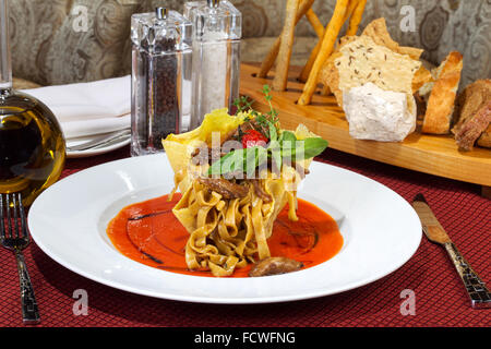 Lasagne italienne avec tomate et légumes et sauce sur une assiette blanche Banque D'Images