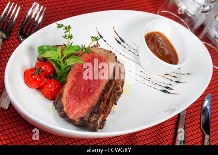 Les steaks grillés moyen et salé sauce tomate Banque D'Images