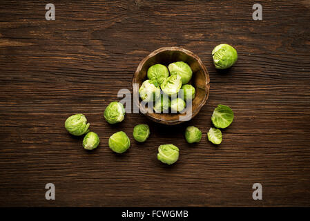 Tas de choux de Bruxelles frais dans une tasse sur fond de bois. Banque D'Images