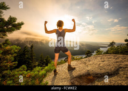 Une jeune femme se tend sur une montagne oublier dans l'Acadia National Park, Mount Desert Island, dans le Maine, la Nouvelle Angleterre, USA. Banque D'Images