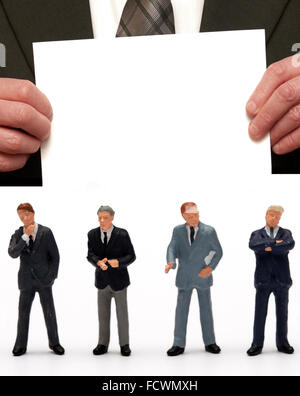 Figurine miniature hommes habillés en costumes d'affaires sous le message "Message vide' sur une carte étant détenu par un homme en costume Banque D'Images