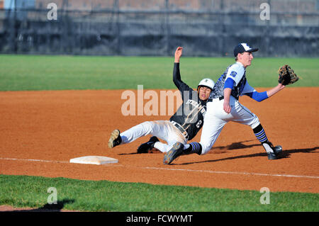 High school base runner glisse en toute sécurité dans la troisième base avec un vol de base que le joueur accepte un pas de la catcher. Banque D'Images