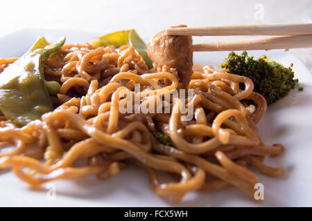 Nouilles chinoises légumes, poulet et baguettes Banque D'Images