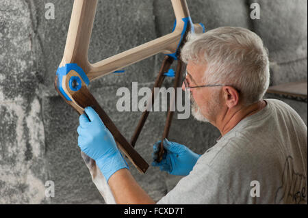 Des artisans qualifiés créer de beaux cadres en bois à partir de bois brut pour créer, haut de gamme cher des vélos. Banque D'Images