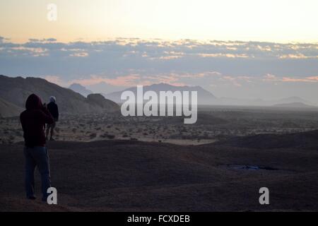 Deux voyageurs voir le soleil se lever près de Mount Spitzkoppe en Namibie, Afrique Banque D'Images