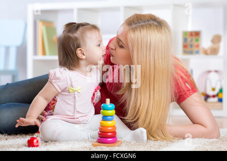 Mère et fille à l'intérieur jouant et souriant Banque D'Images