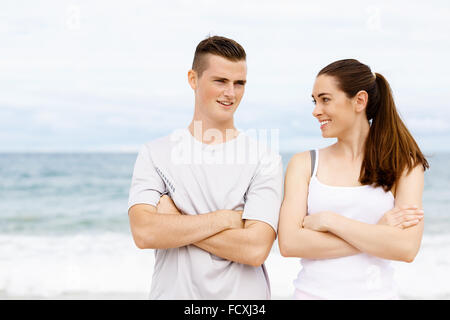 Jeune couple en se tenant sur le plage de vêtements sports Banque D'Images