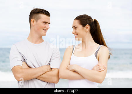 Jeune couple en se tenant sur le plage de vêtements sports Banque D'Images