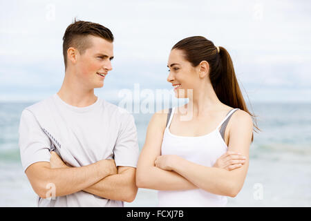 Jeune couple en se tenant sur le plage de vêtements sports Banque D'Images