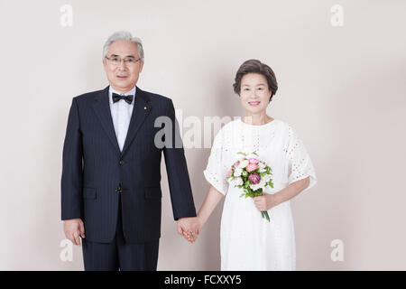 Vieux couple mariage main dans la main regardant à l'avant avec le sourire Banque D'Images
