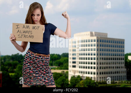 Une belle jeune femme tenant une adolescente panneau qui dit que je ne suis pas toujours forte Banque D'Images