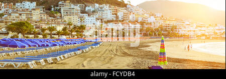 TENERIFE, ESPAGNE - 17 janvier 2013 : plage de sable avec parasols et chaises longues bleu, Los Cristianos, Tenerife, Canaries, Espagne Banque D'Images