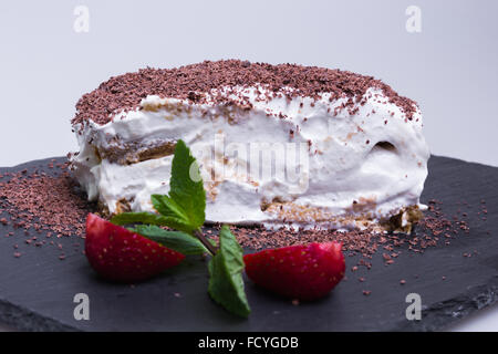 Gâteau dessert Tiramisu aux fraises sur le bac en ardoise noire Banque D'Images