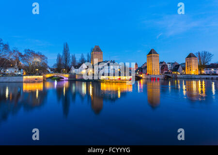 Barrage Vauban illuminée et Ponts Couverts au crépuscule se reflétant dans les eaux de l'Ill, Alsace France Banque D'Images