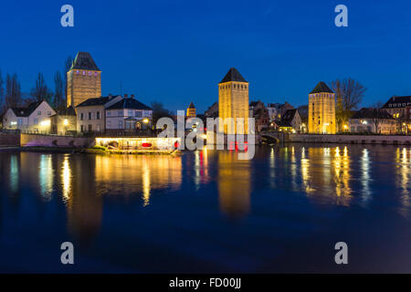 Barrage Vauban illuminée et Ponts Couverts au crépuscule se reflétant dans les eaux de l'Ill, Alsace France Banque D'Images